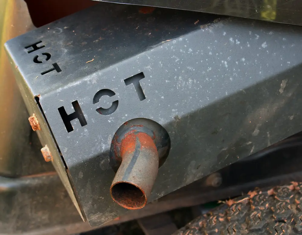 Closeup of a muffler, which can be a cause for why a lawn mower loses power when cutting.