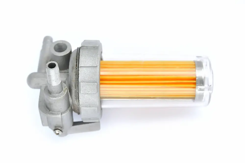 Closeup of a fuel filter on a white background.