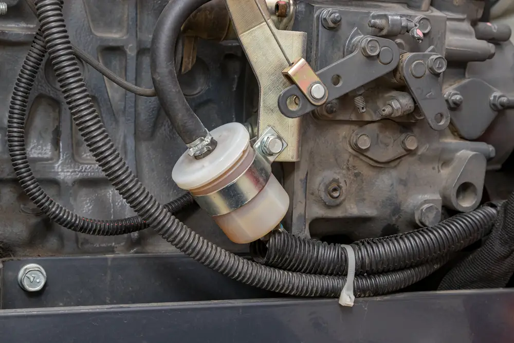 Closeup of a fuel filter attached to a machine.