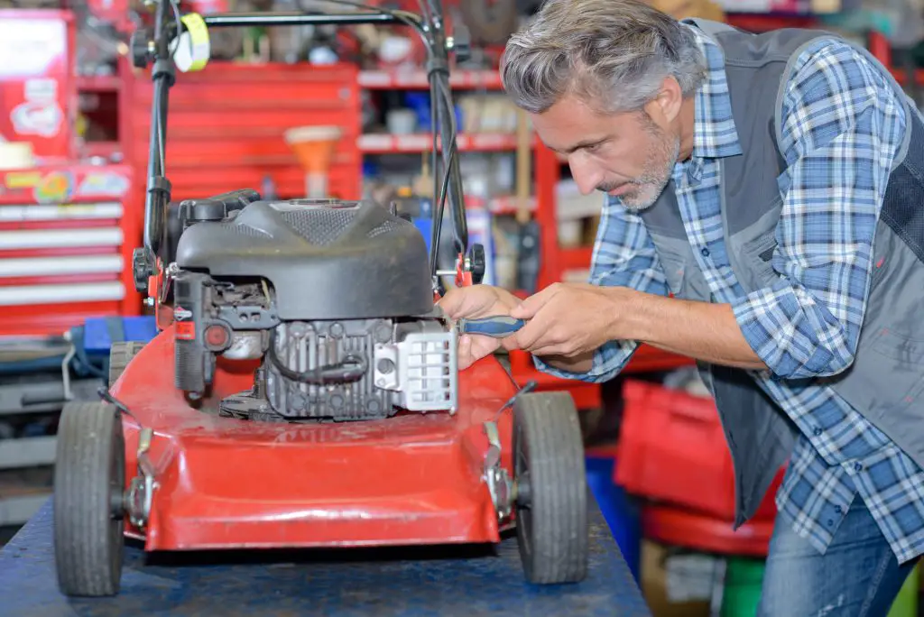 A man fixing his lawn mower.