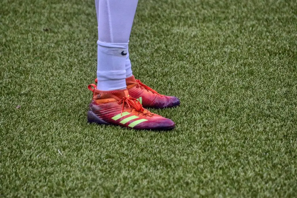 A soccer player standing on an artificial grass field.