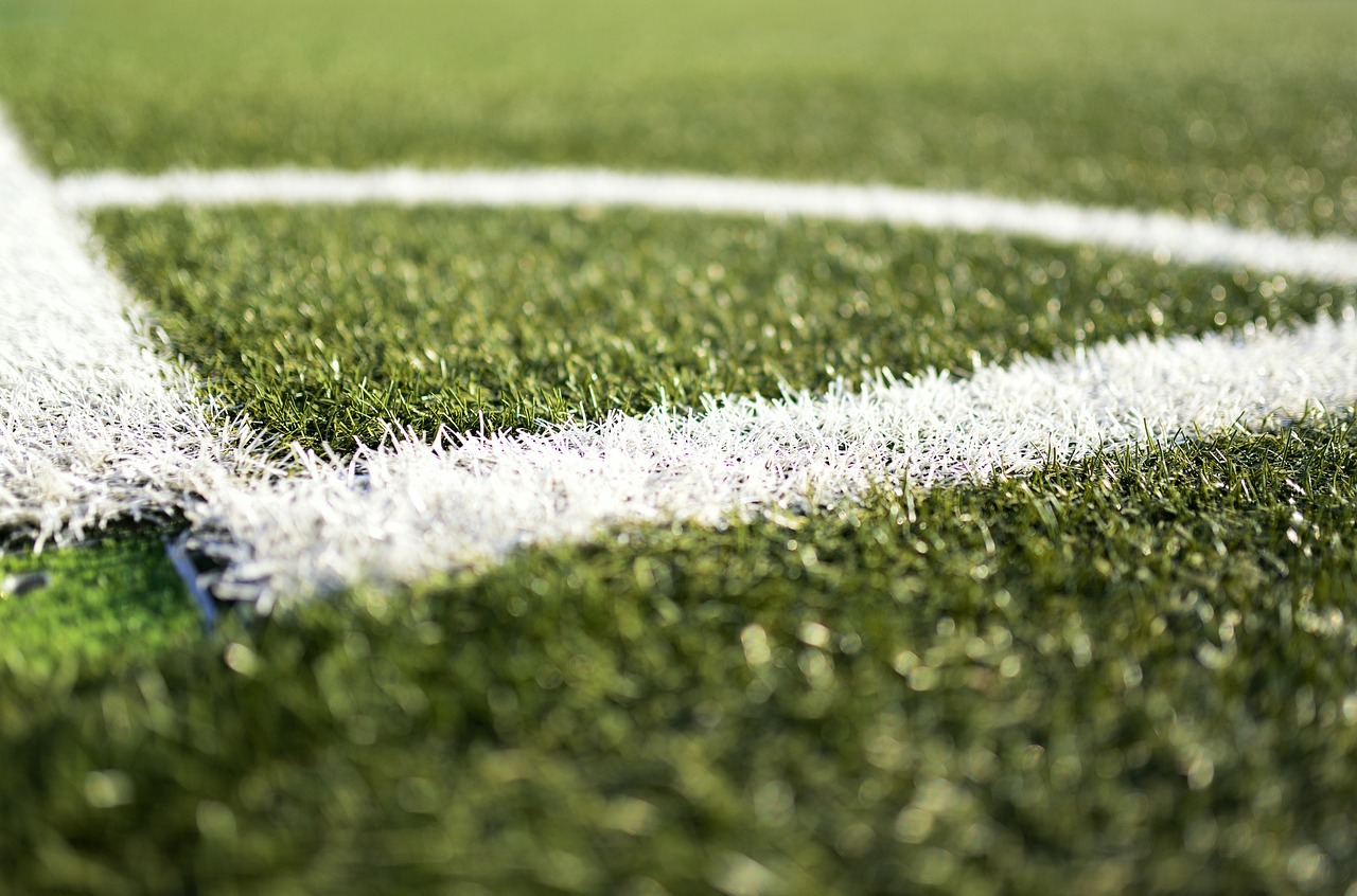 A closeup of the corner of an artificial grass soccer field.
