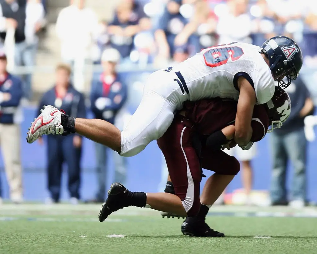 A football player tackling another one.