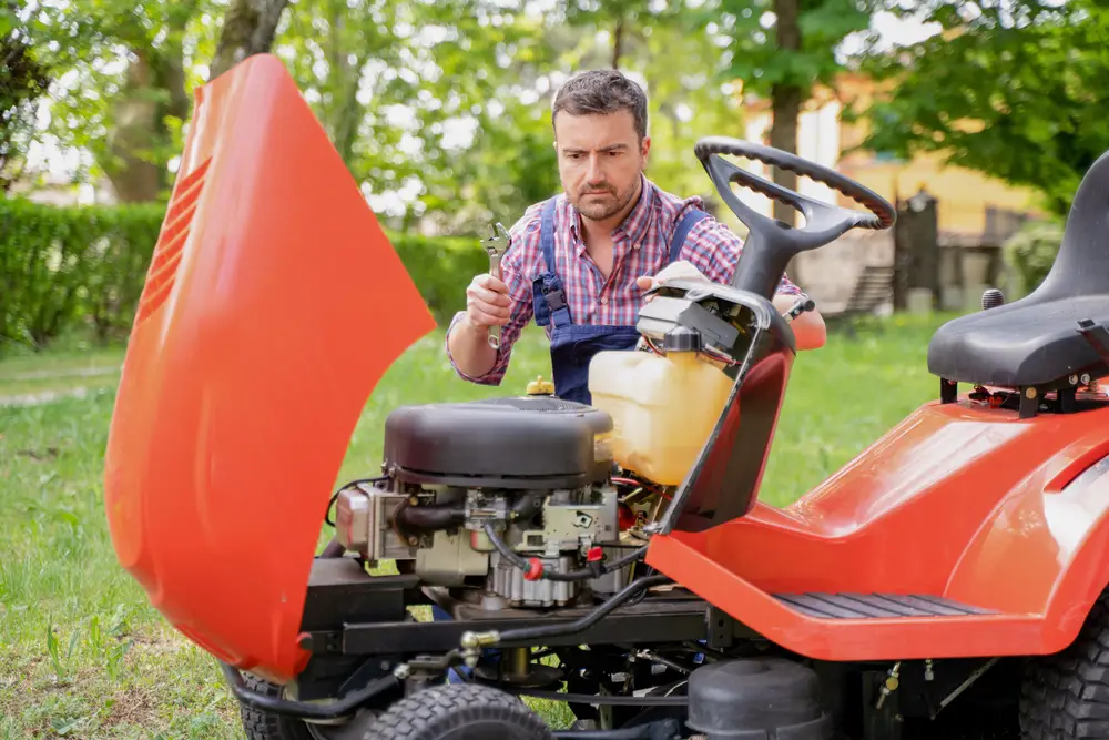 Man about to start working on lawn mower.