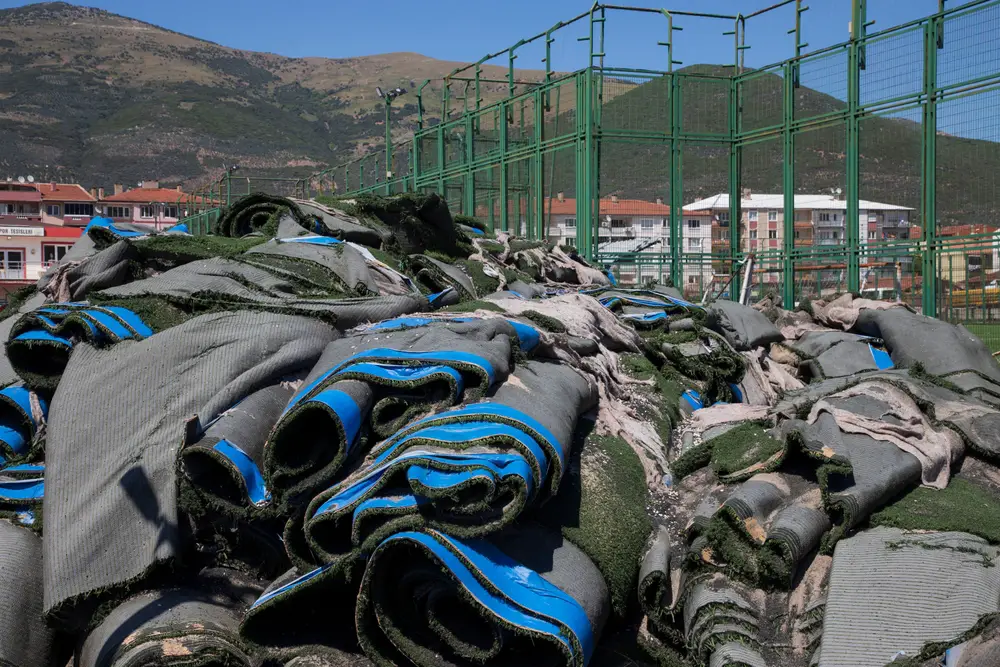 Artificial grass rolls tossed in a heap.