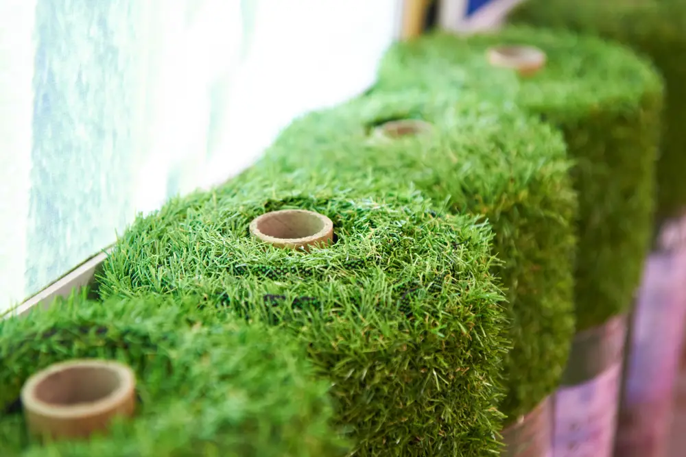 A closeup of artificial grass rolls in a store.