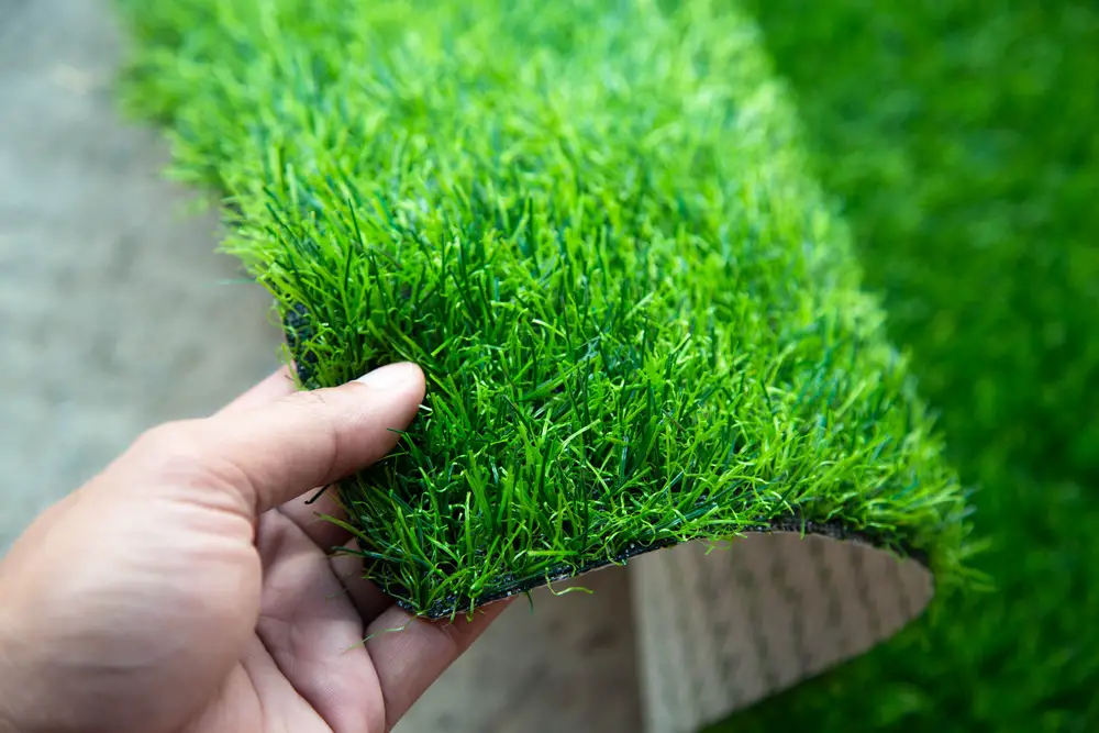 Someone holding an artificial grass mat.