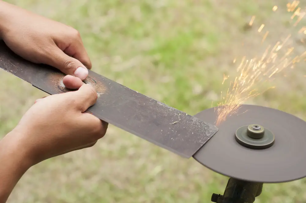 Someone sharpening a lawn mower blade.