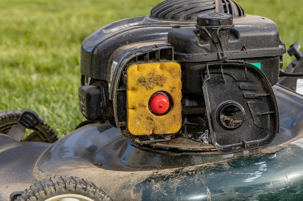 A dirty air filter on a lawn mower.